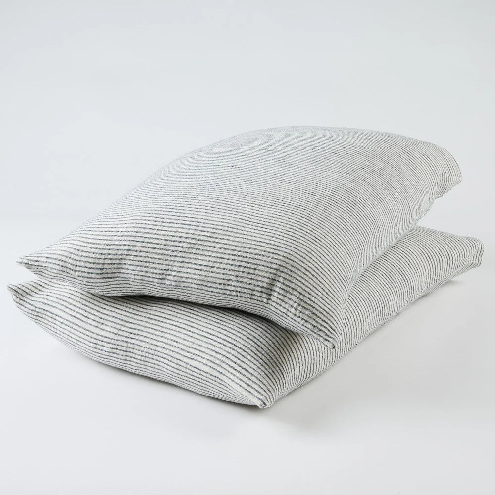 Two white and ink blue pin striped pillows on a white background