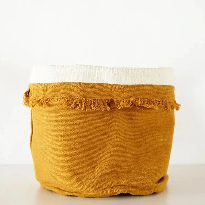 Mustard yellow fabric with frayed edge on a white background