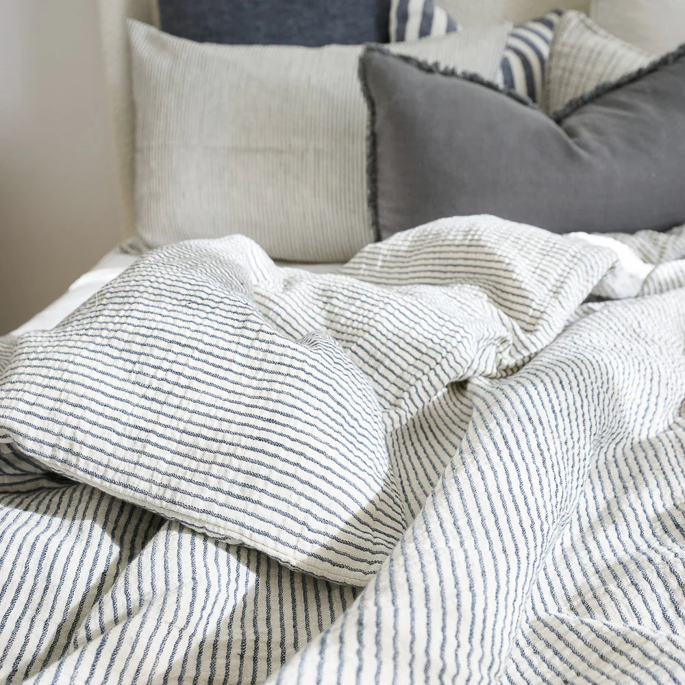 Textured striped blanket and pillows on a sofa