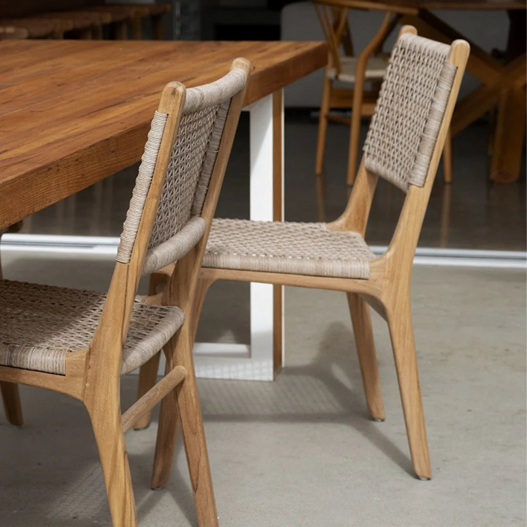 Wooden chairs with woven seats at a dining table in a casual setting.
