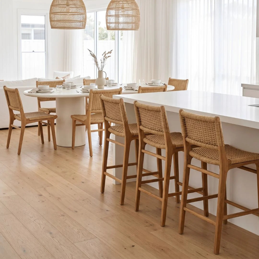 Modern kitchen with wooden chairs around a dining table and island.