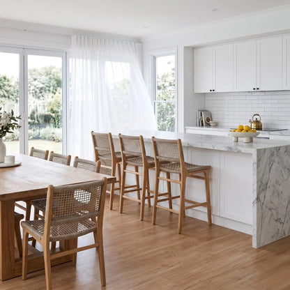 Modern kitchen with marble island, wooden dining table, and chairs.