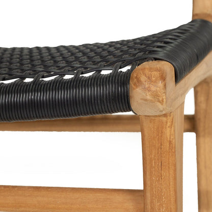 Close-up of a wooden chair with a black woven seat strap on a white background.