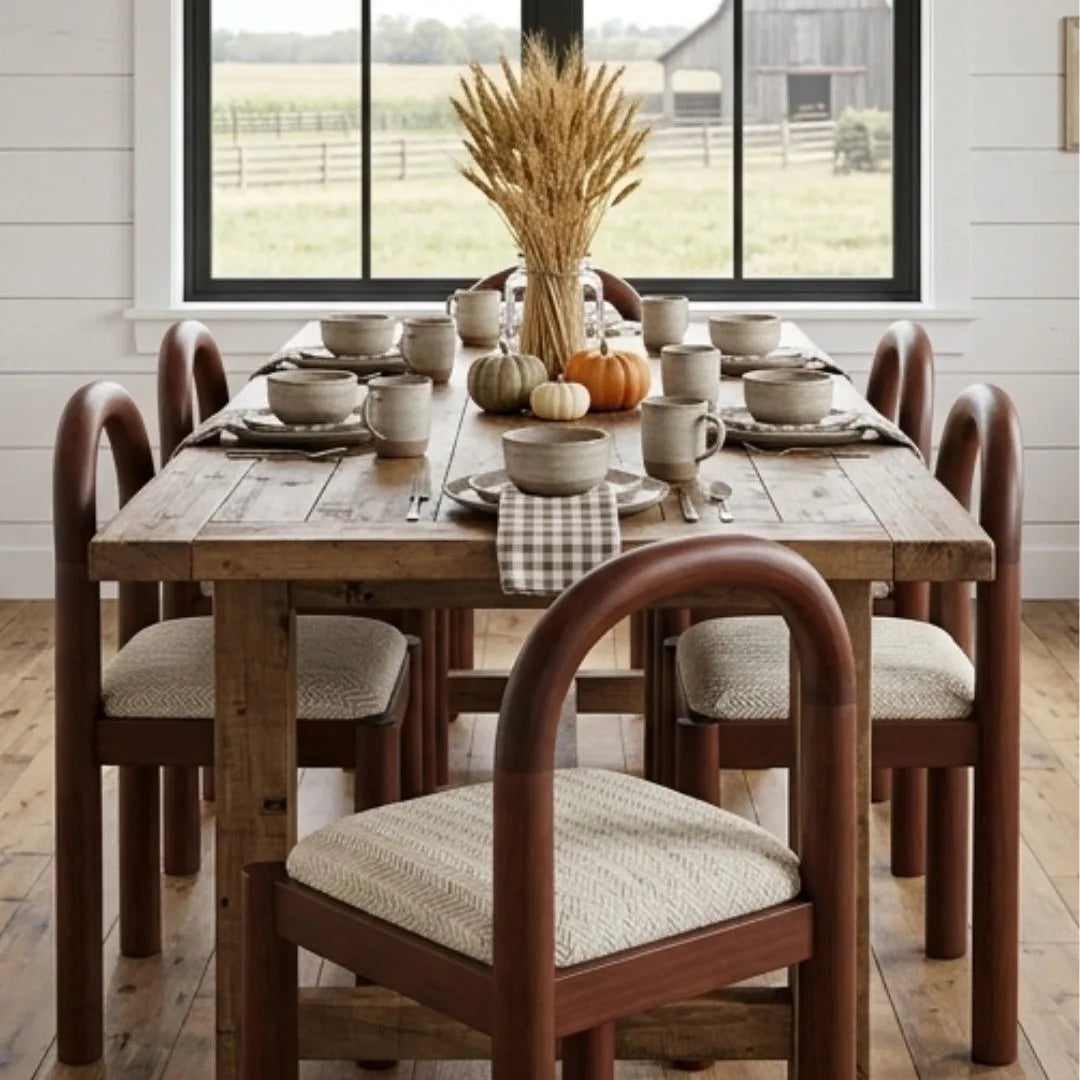 Dining room with wooden table and chairs, set for a meal with fall decorations.