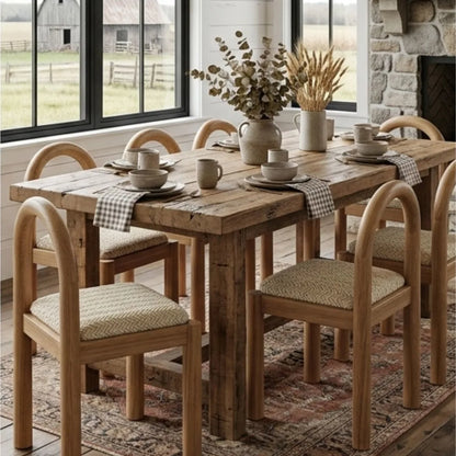 Dining room with wooden table and desa chairs, set for a meal with decorative elements.