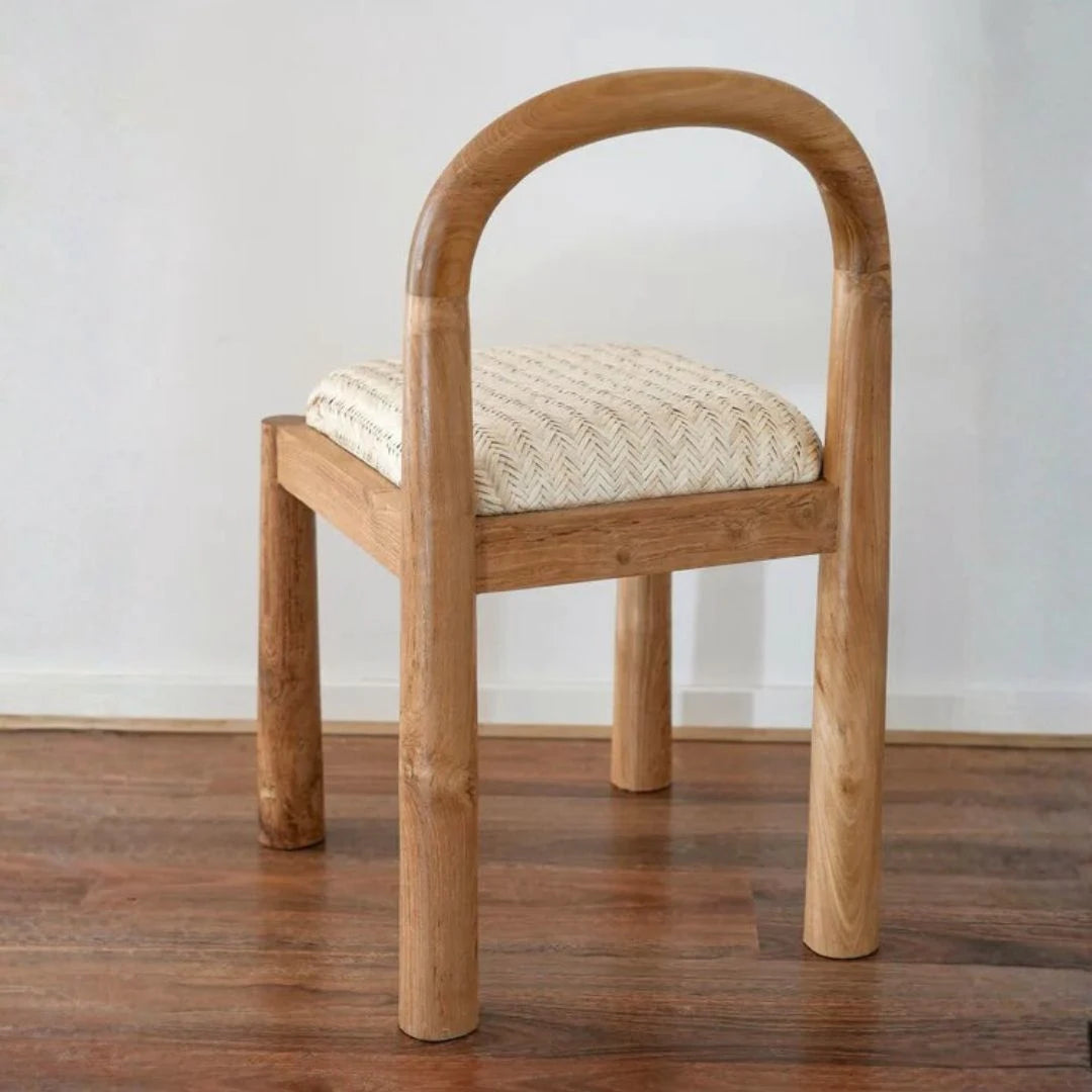 Desa Teak dining chair with woven seat on a wooden floor against a white wall
