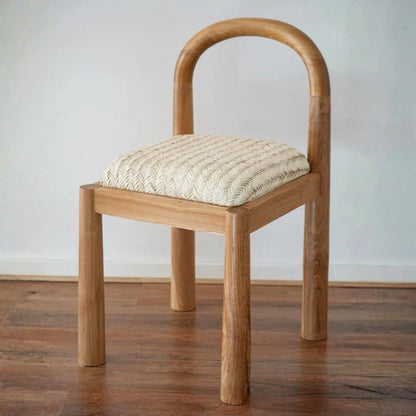 Desa Teak dining chair with woven seat on a wooden floor against a white wall