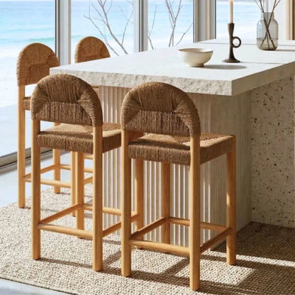 Set of wooden bar stools with woven seats in a modern kitchen.
