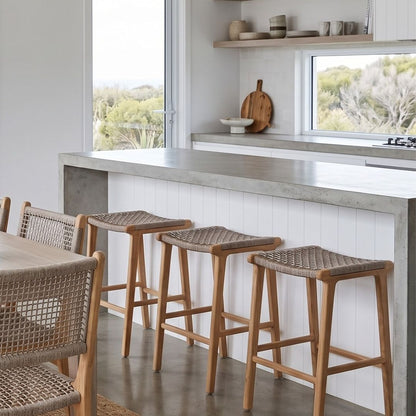 Modern kitchen with wooden stools and chairs near a concrete countertop.