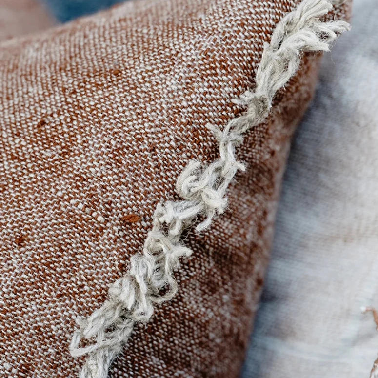 Close-up of textured pillows with lace trim on a blurred background