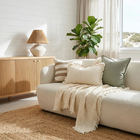 Cozy living room with a beige sofa, lamp, and plant