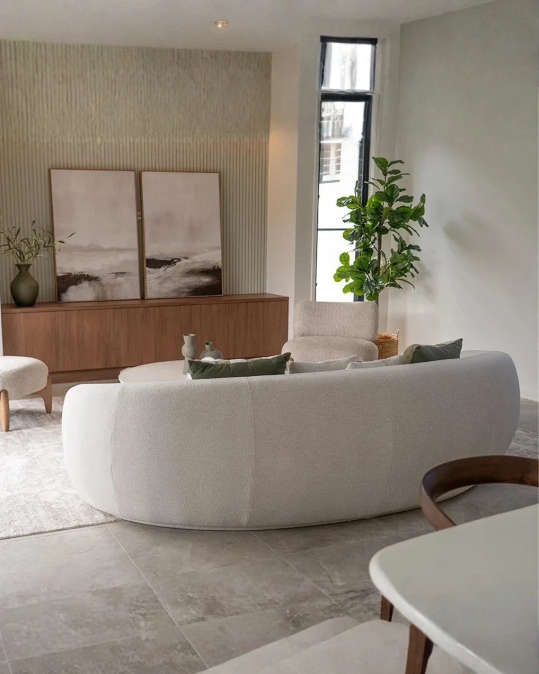 Modern living room with a white sofa, wooden sideboard, and decorative elements.