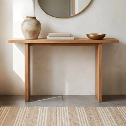 Wooden console table with decorative items against a neutral wall.