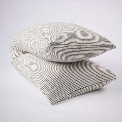 Two square throw pillows stacked on top of each other, featuring a fine vertical stripe pattern in gray and off-white on a clean white background.