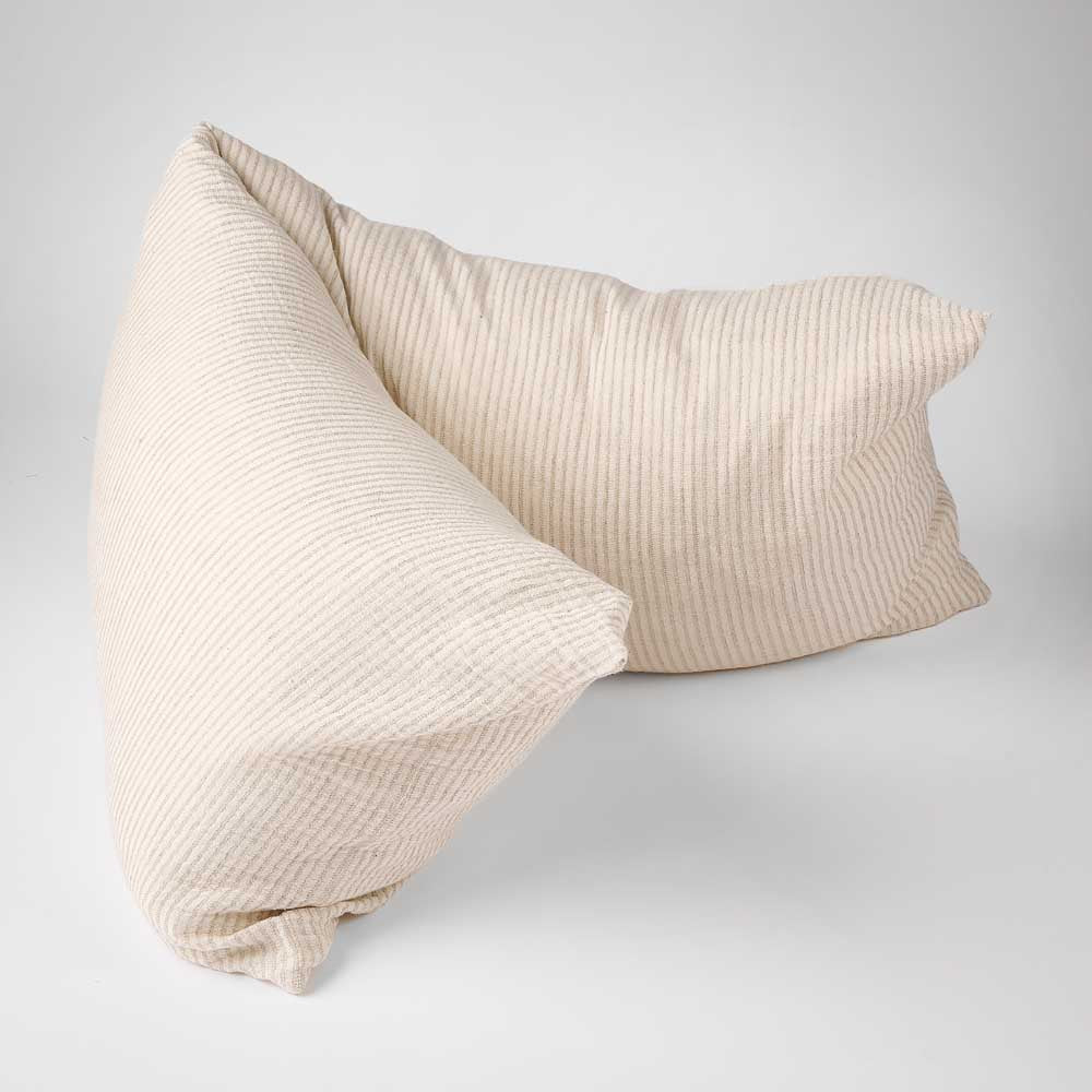 Two textured cream-colored throw pillows with a subtle vertical stripe pattern, arranged on a light gray studio background.