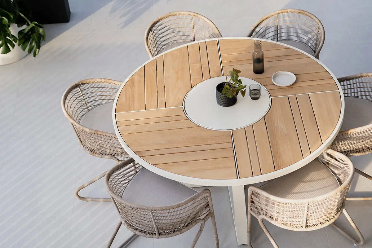 Round wooden dining table with chairs on a light-colored floor
