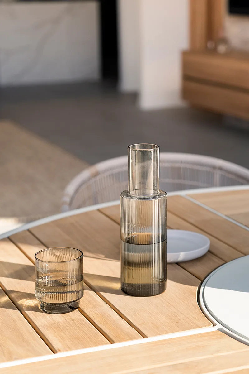 Two glass vases on a wooden table with a blurred indoor background