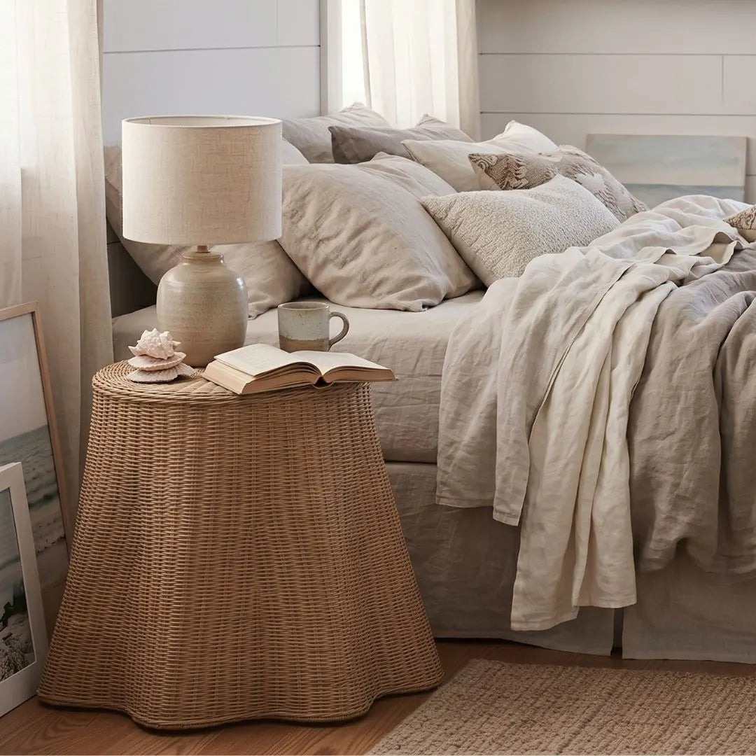 Cozy bedroom with a bed, lamp, and side table with a book and mug.