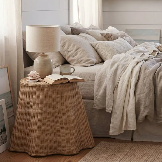 Cozy bedroom with a bed, lamp, and side table with a book and mug.