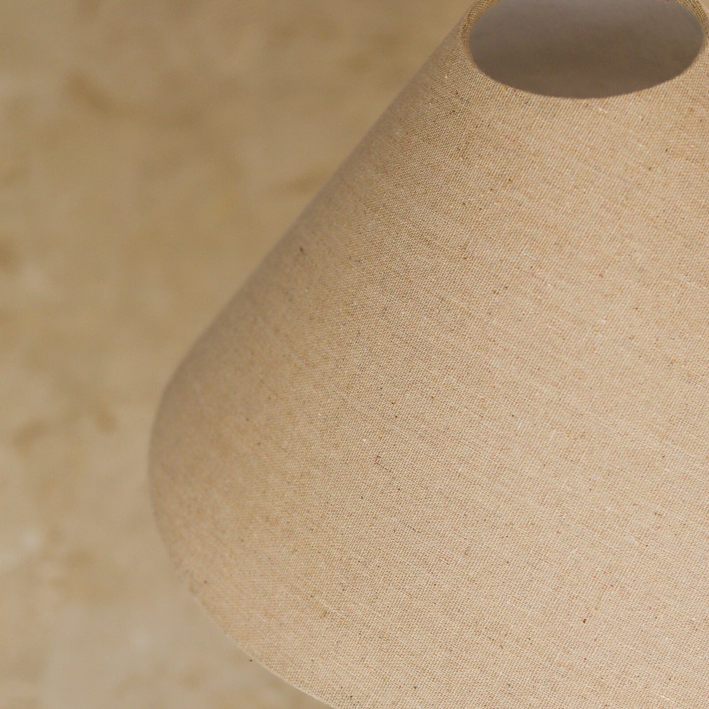 Close-up of a beige fabric lampshade with a blurred background