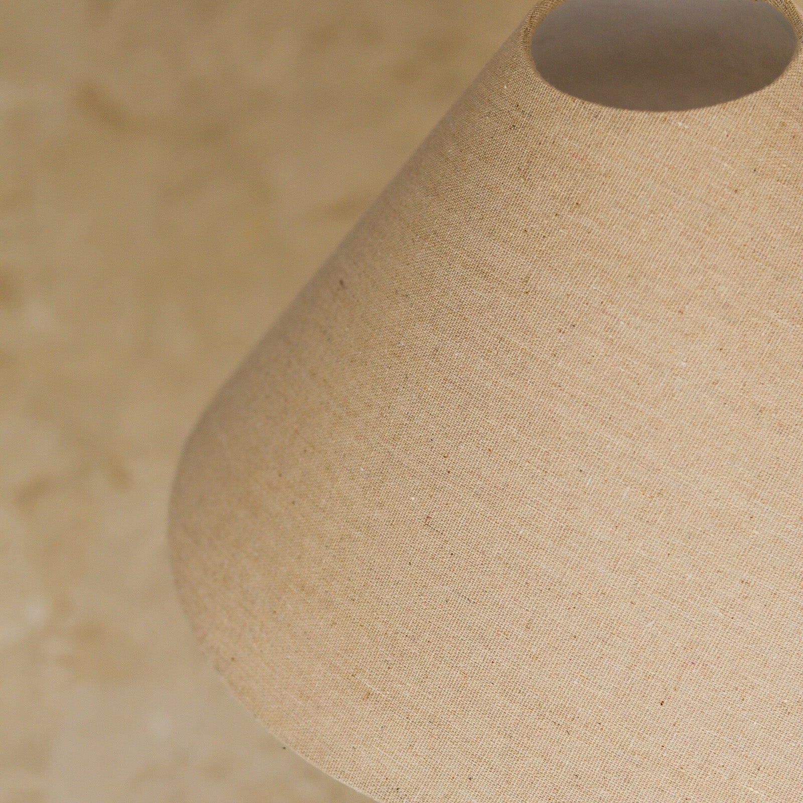 Close-up of a beige fabric lampshade with a blurred background