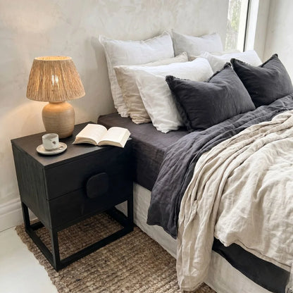 Cozy bedroom with a bed, nightstand, and lamp.