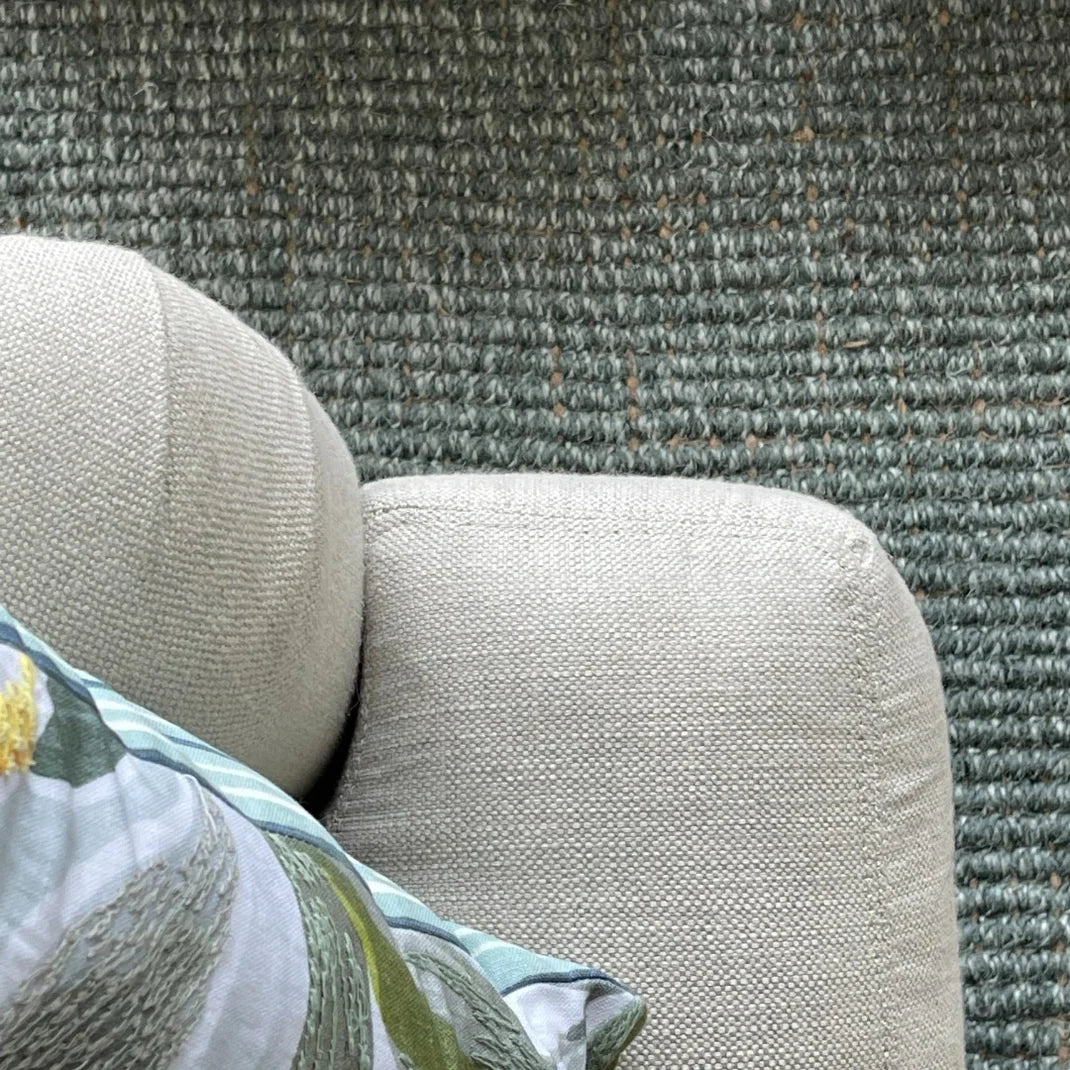 Close-up of a textured fabric surface with a floral pillow.