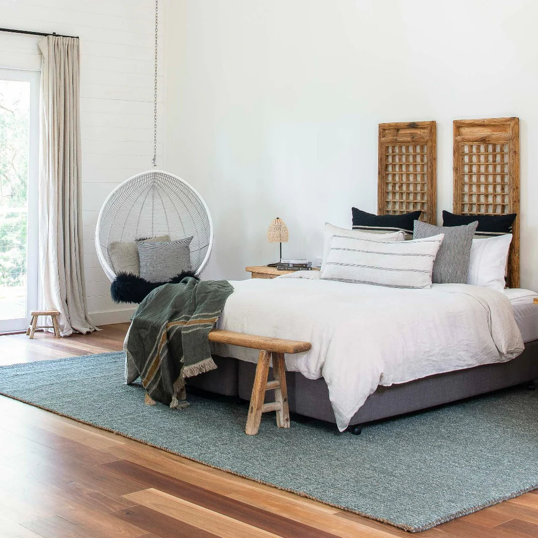 Modern bedroom with a bed, chair, and decor elements.