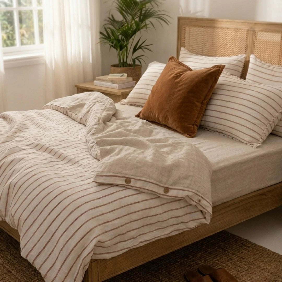 Bedroom with wooden bed, striped bedding, and a plant on a nightstand.