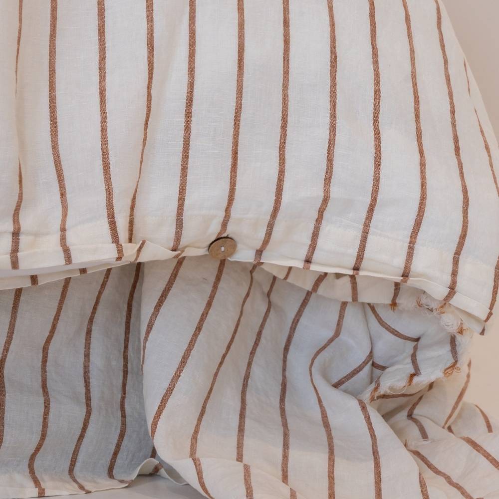 Close-up of a striped duvet cover with brown and white lines.