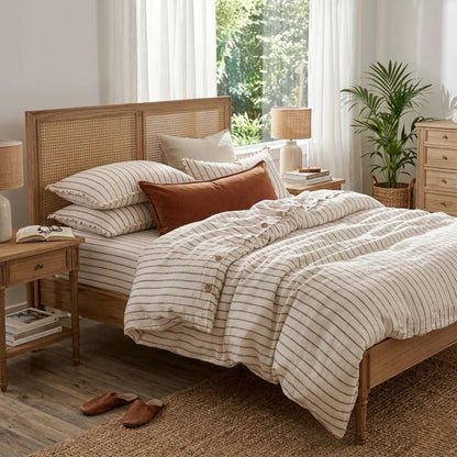 Bedroom with wooden bed, striped bedding, and side tables.