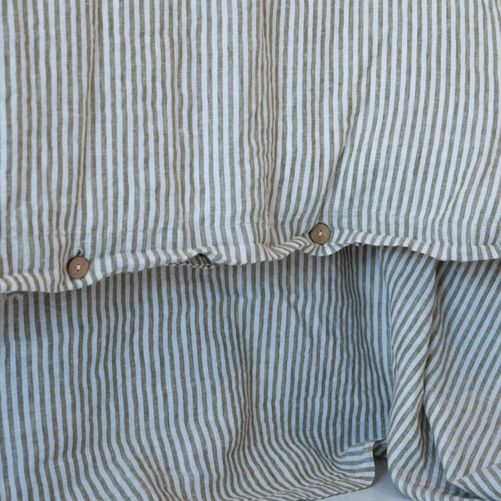 Close-up of a olive striped duvet cover with buttons.