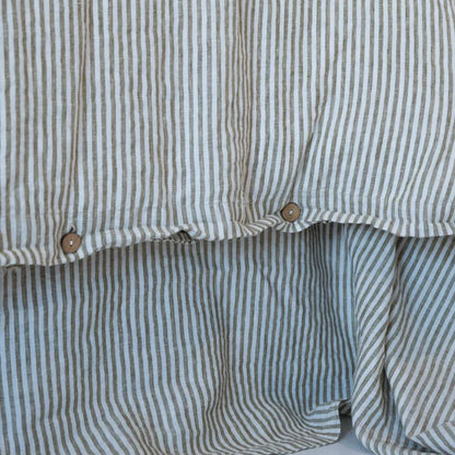 Close-up of a olive striped duvet cover with buttons.