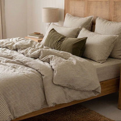 Bedroom with wooden bed, striped bedding, and wicker headboard.