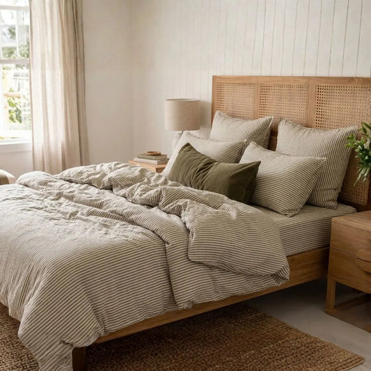 Bedroom with wooden bed, french linen white and olive striped bedding by Sun Republic