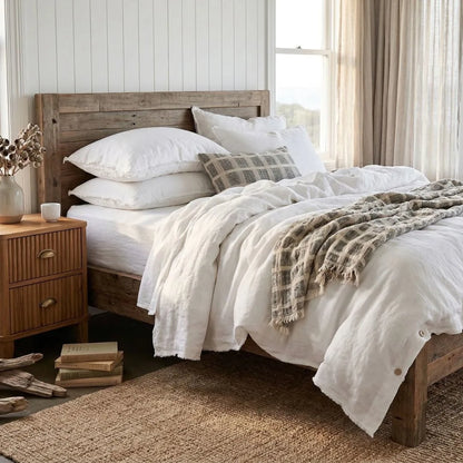 Cozy bedroom with wooden bed, white bedding, and a wooden nightstand.