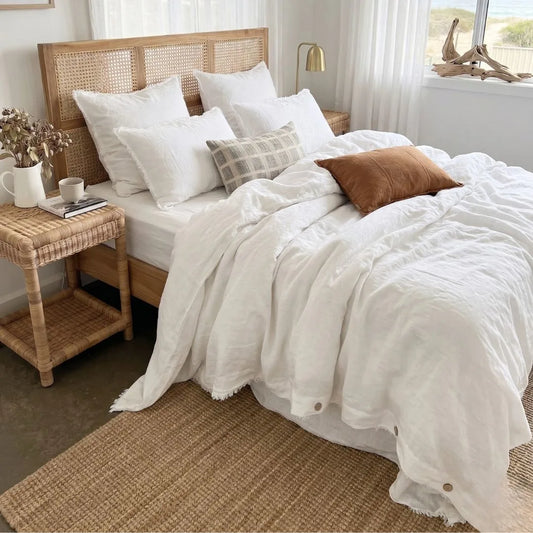 Bedroom with a wooden bed frame, white bedding, and decorative pillows.
