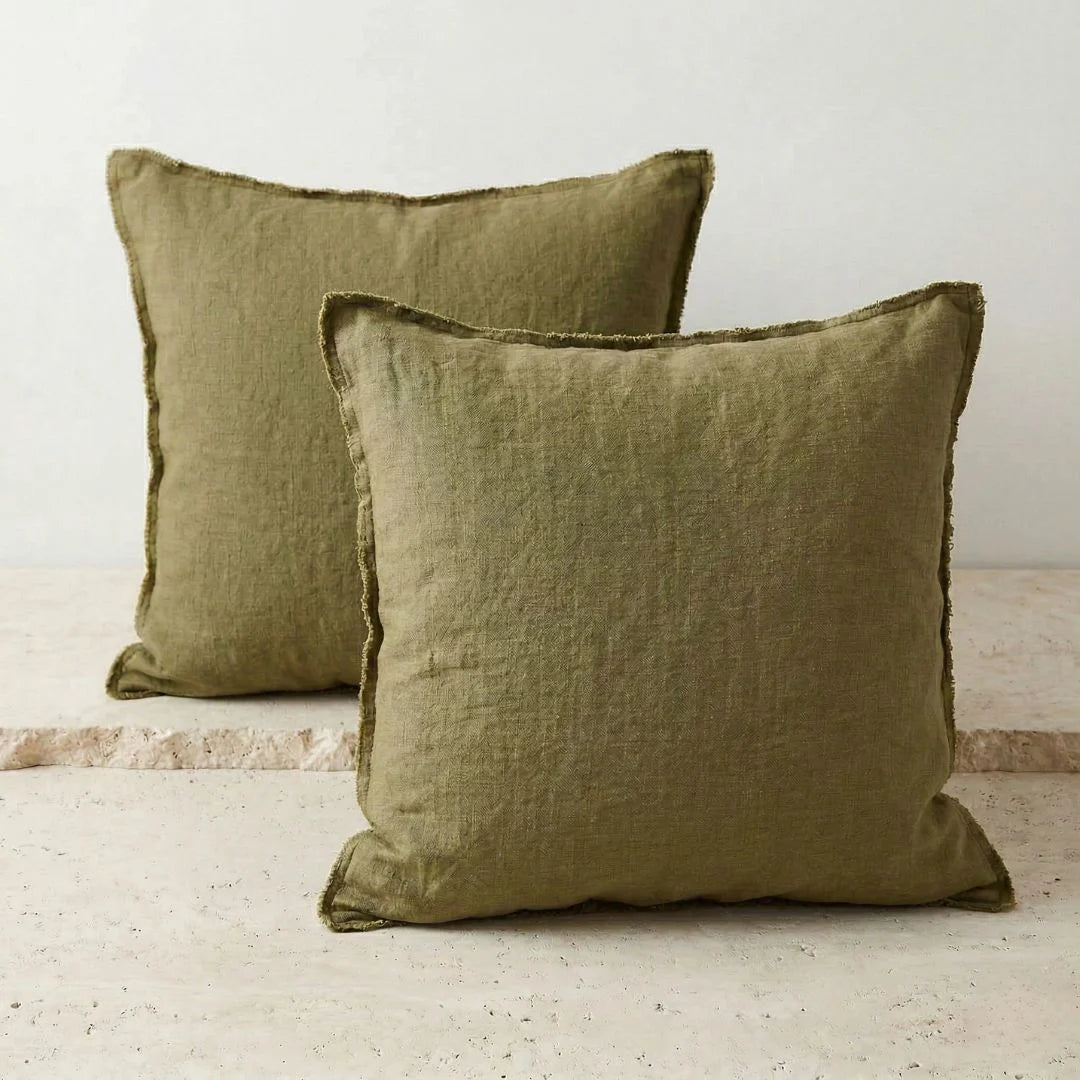 Two olive green pillows on a neutral background