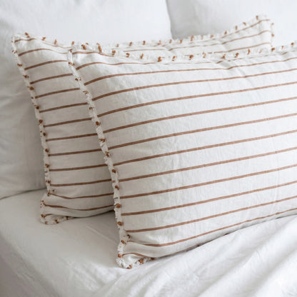 Two striped pillows on a white bed