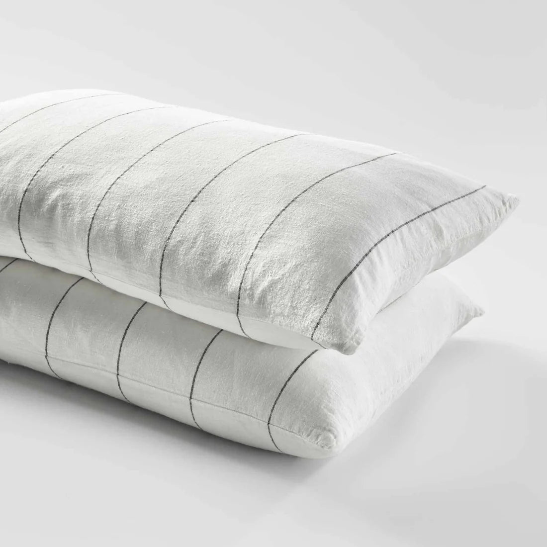Two gray pillows with striped pattern on a light gray background