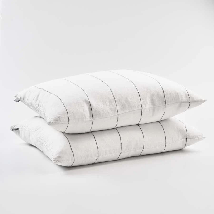 Two white pillows with gray stripes on a light gray background