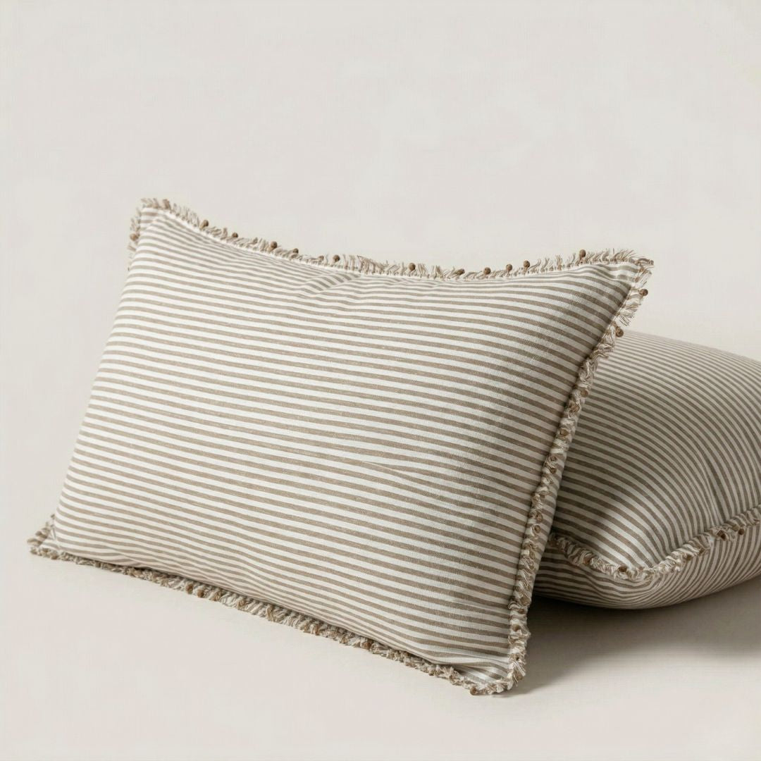 Two striped pillows with frayed edges on a light background