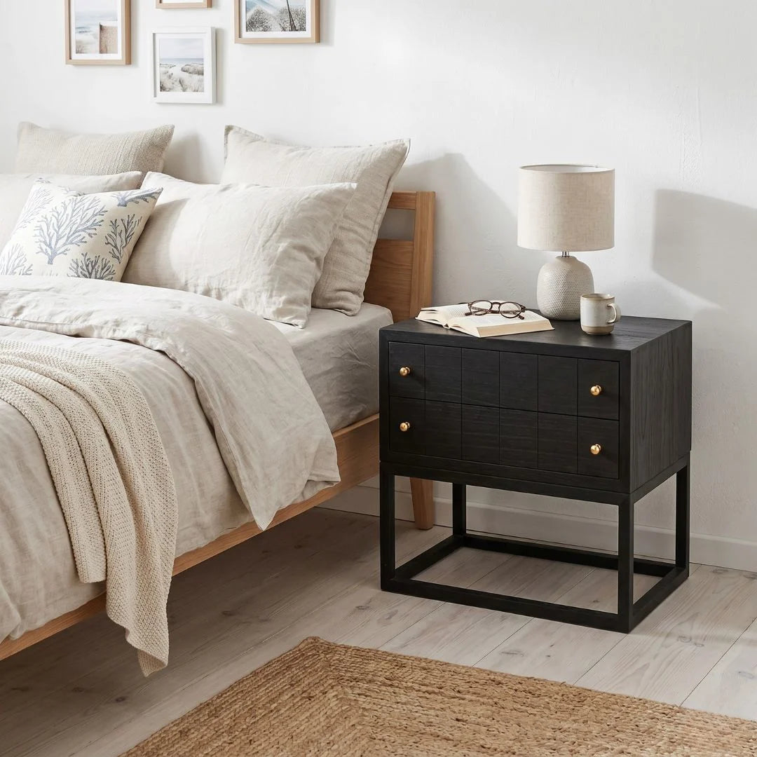 Black bedside table featured in a modern bedroom setting