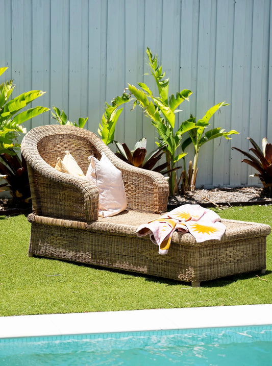 Wicker outdoor lounge chair with cushions by a poolside