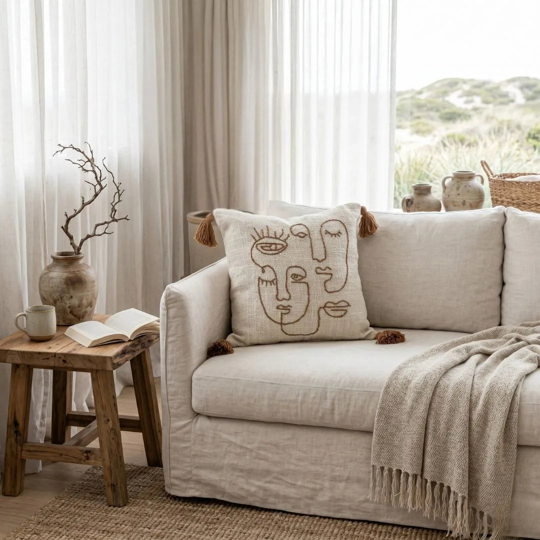 Cozy living room with a beige sofa, decorative pillow, and wooden side table.