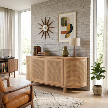 A light natural wood sideboard cabinet with woven cane panels, styled in a bright, modern living room against a white brick wall.