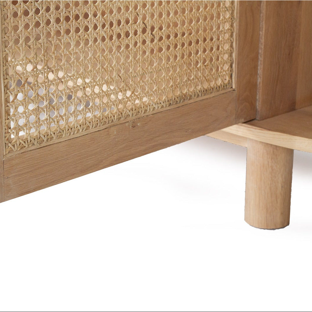 Close-up of a light natural wood furniture piece with a woven cane or rattan panel on a white background.