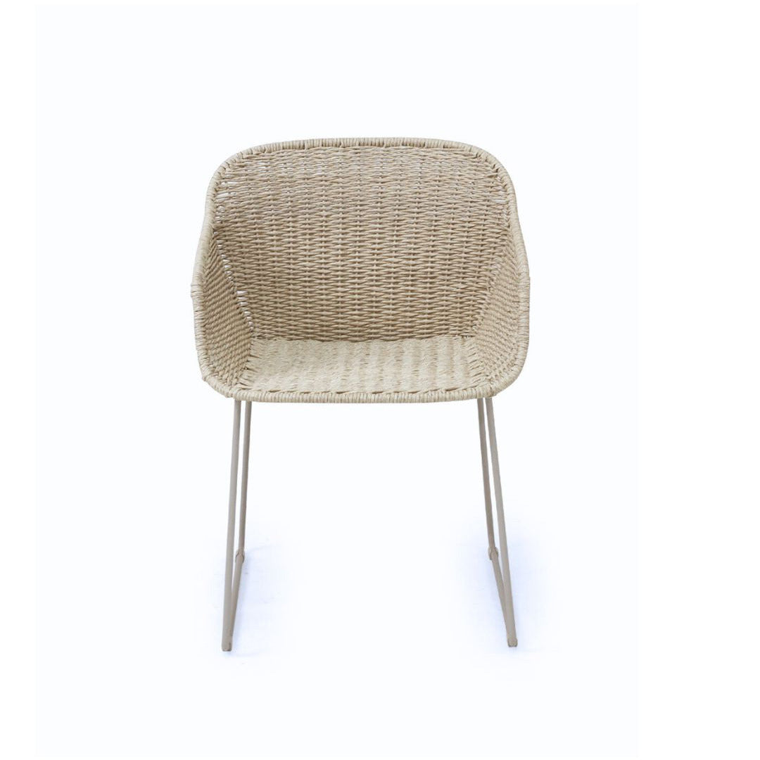 A modern outdoor dining chair with a woven beige wicker seat and backrest, supported by slim silver metal legs, shown against a plain white background.