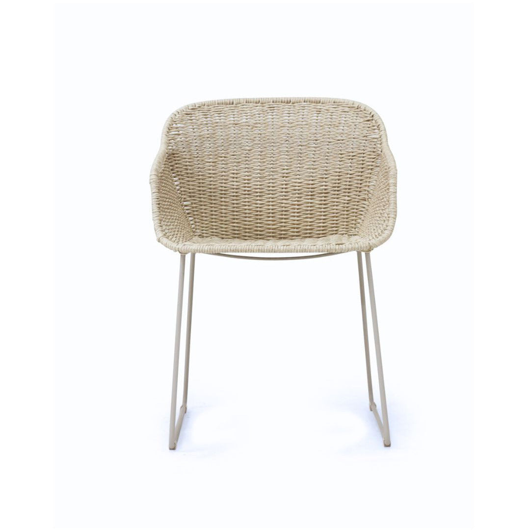 A modern outdoor dining chair with a light beige woven rattan seat and back, supported by slim silver metal legs, shown against a plain white background.