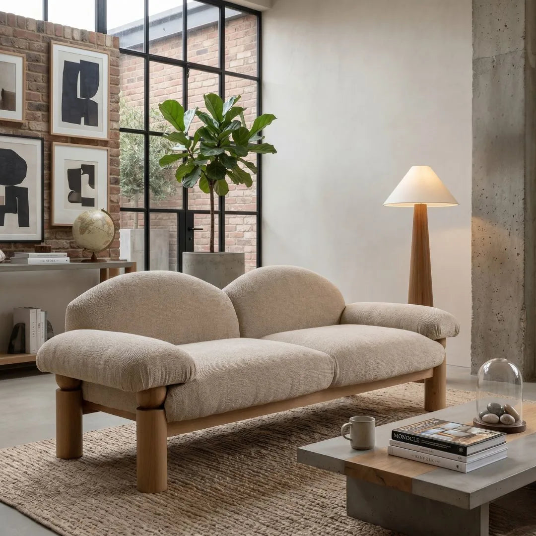 Beige sofa in a modern living room with a coffee table, lamp, and decorative items.